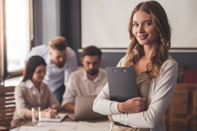 Beautiful young business lady is looking at camera.