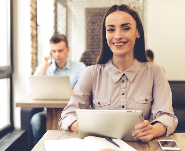 Beautiful young business woman is using a digital tablet.