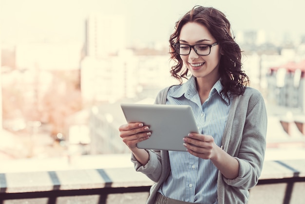 Beautiful young business woman is using a digital tablet.