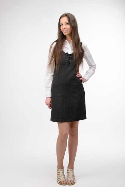 Beautiful young business woman standing, on white wall