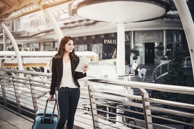 Beautiful young businesswoman walking outside public transportation station