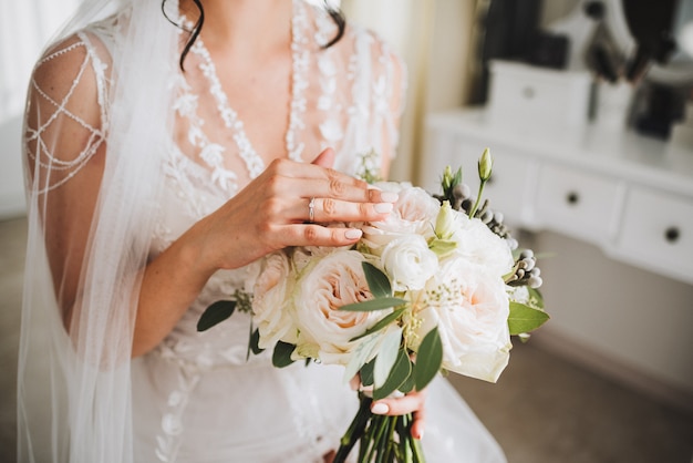 Beautiful young Caucasian bride holding her wedding bouquet