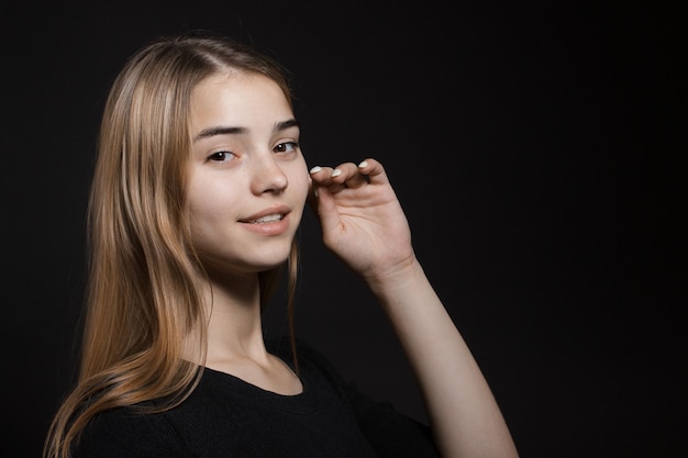 Beautiful young caucasian woman portrait on black background