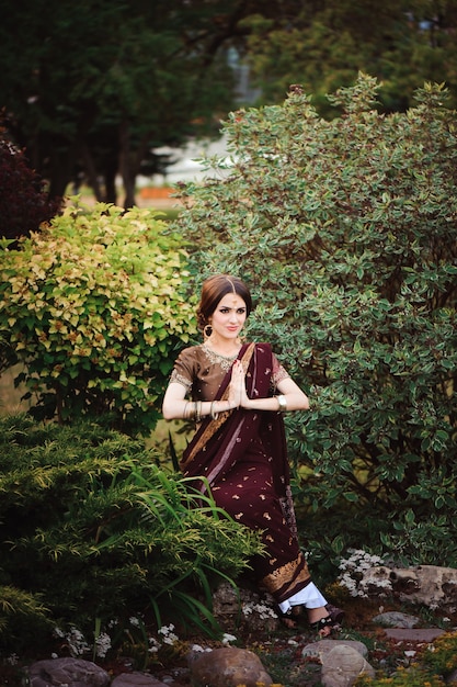 Beautiful young caucasian woman in traditional indian clothing sari with bridal makeup and jewelry and henna tattoo on hands.