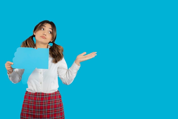 Beautiful young college lady holding unlike sign and point hand away. High quality photo