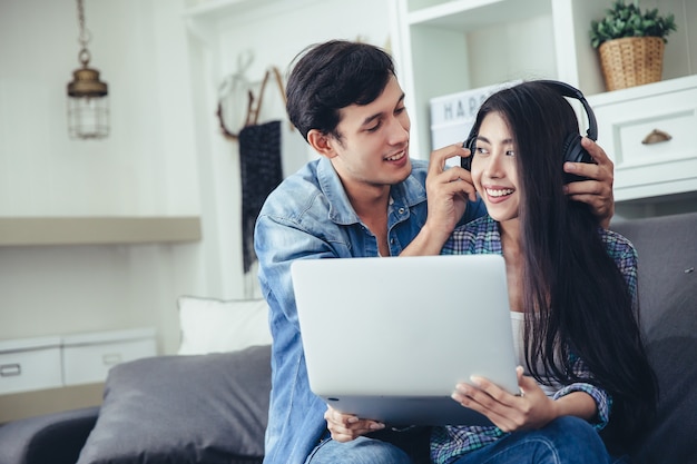 Beautiful young couple is feeding smiling while using notebook 