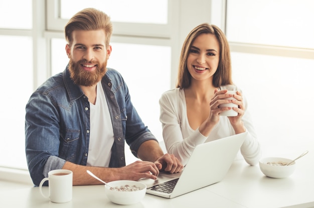 Beautiful young couple is using a laptop.