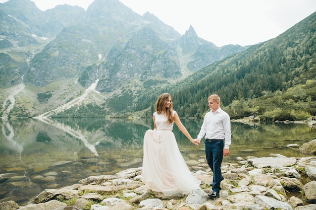 A beautiful young couple at the lake in Tatra mountains in Poland Morskie Oko