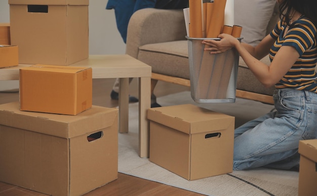 Beautiful young couple in love having fun unpacking things from cardboard boxes while moving in together in their new apartment