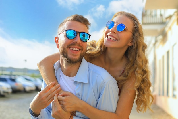 Beautiful young couple in love walking outdoors at the city street hugging