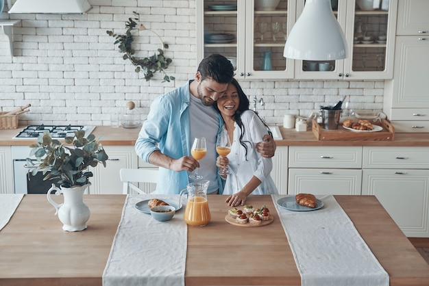 Beautiful young couple preparing breakfast together while spending time in the domestic kitchen