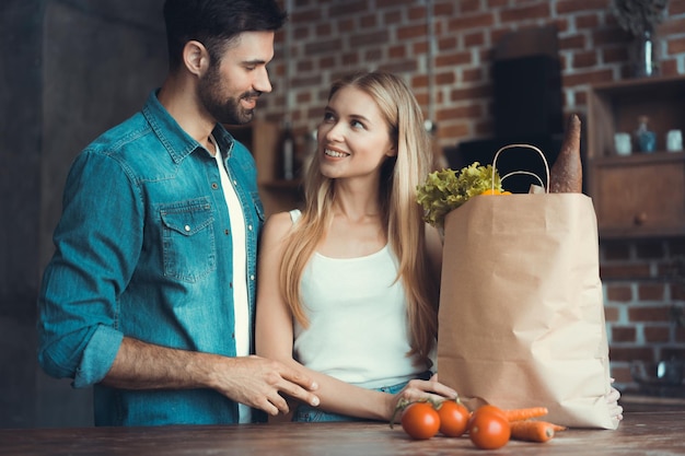 Beautiful young couple preparing a healthy meal together while spending free time at home