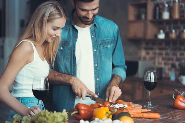 Beautiful young couple preparing a healthy meal together while spending free time at home