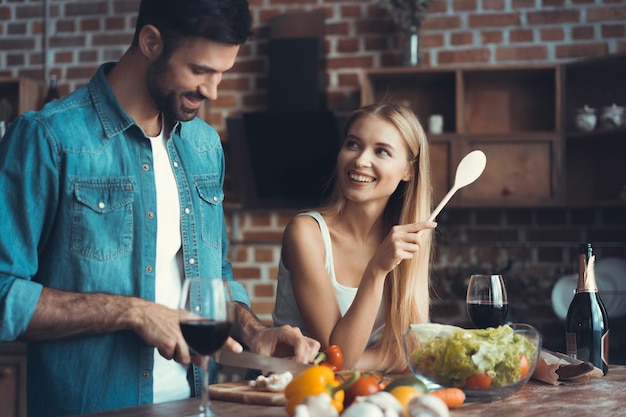 Beautiful young couple preparing a healthy meal together while spending free time at home