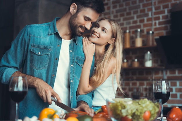 Beautiful young couple preparing a healthy meal together while spending free time at home