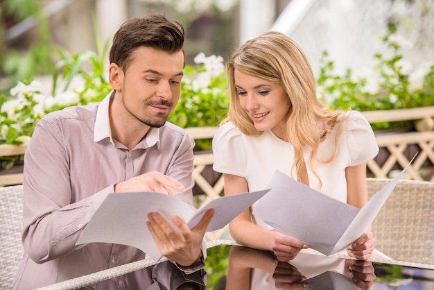 Beautiful young couple reading menu at restaurant.