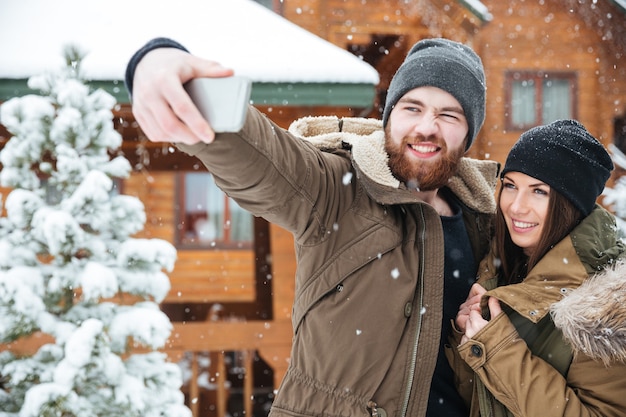 Beautiful young couple taking selfie in winter