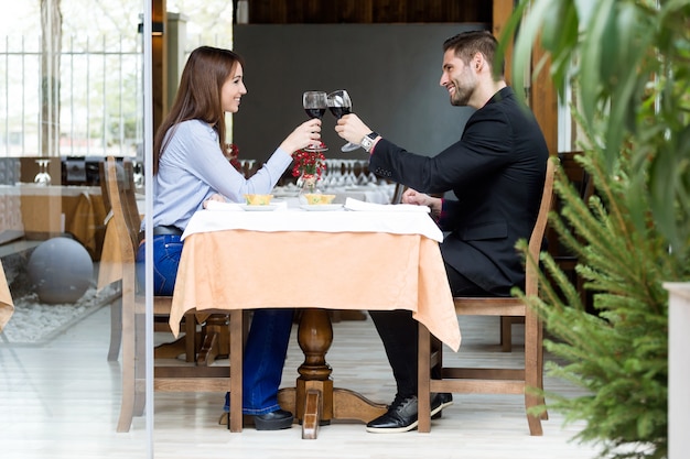 Beautiful young couple toasting wine glasses in the restaurant.