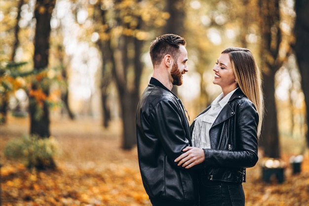 Beautiful young couple walking in the autumn park on a sunny day