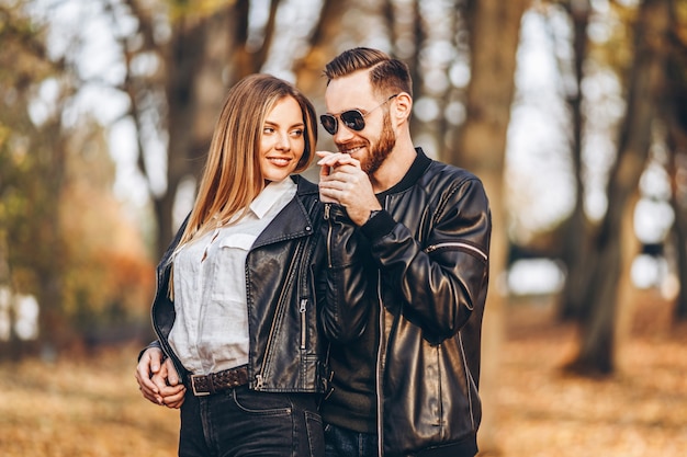 Beautiful young couple walking in the autumn park on a sunny day