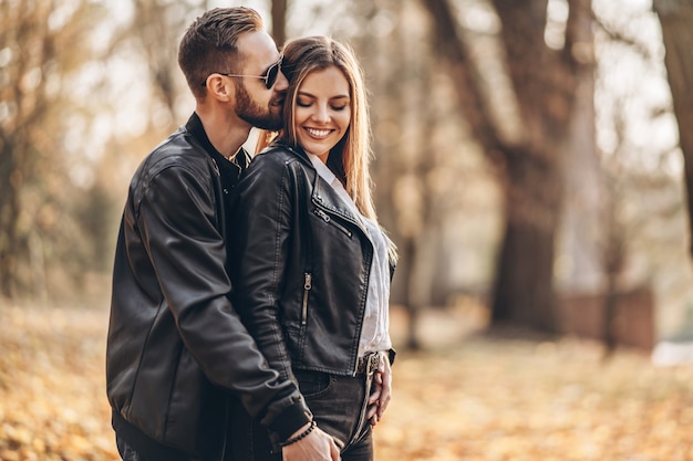 Beautiful young couple walking in the autumn park on a sunny day