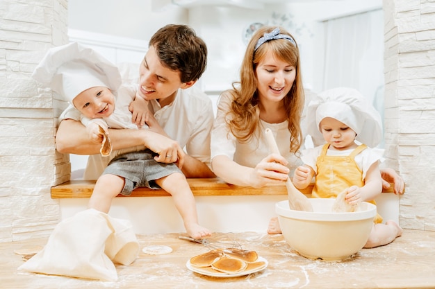 Beautiful young family cute mom and cheerful dad keep their little twoyearold children