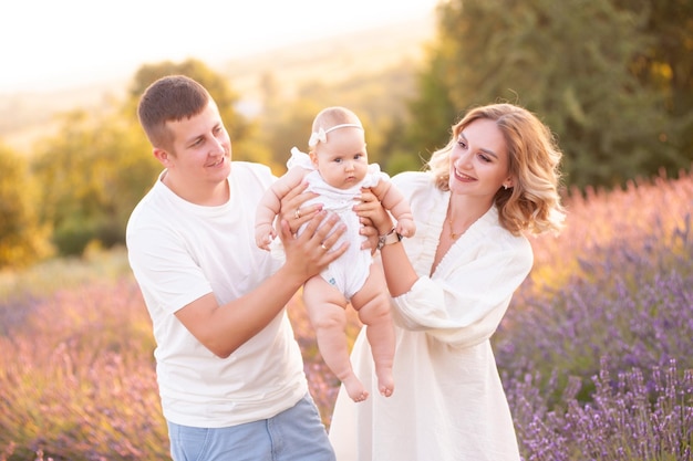 Beautiful young family, father and mother with baby on lavander field