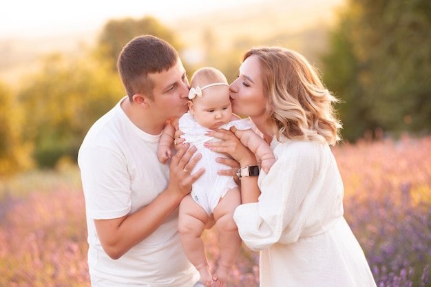 Beautiful young family, father and mother with baby on lavander field