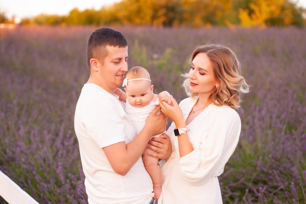 Beautiful young family on purple flower lavender field. Family vacation