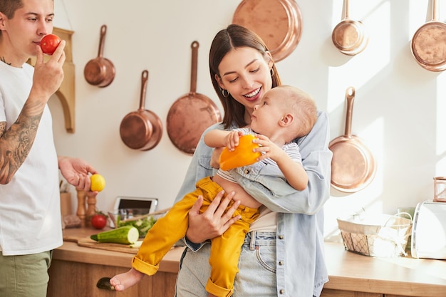 A beautiful young family with a child cooks together