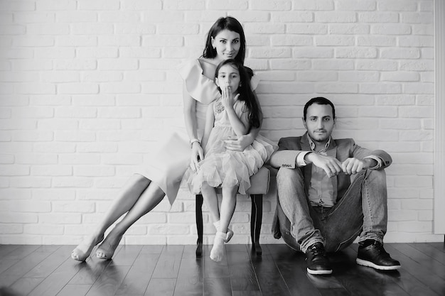 Beautiful young family with daughters at a photo shoot in a white studio