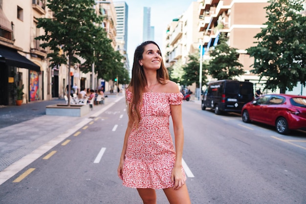 Beautiful young fashionable woman in sexy stylish dress posing in the city with standing on the road