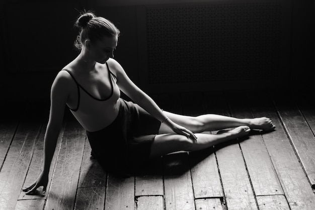 Beautiful young female classical ballet dancer on pointe shoes wearing a black leotard and skirt