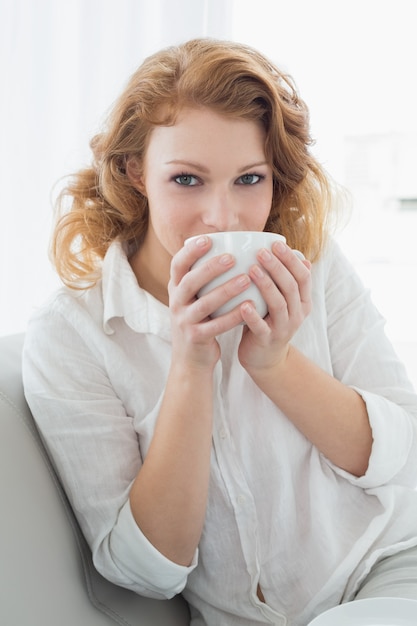 Beautiful young female and drinking coffee at home