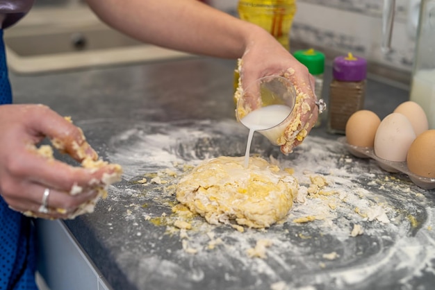 Beautiful young female hands break eggs into flour to knead a beautiful dough Cooking concept