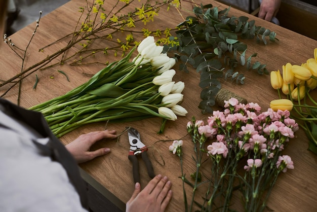 Beautiful young florist makes a bouquet