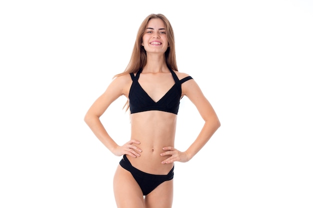 Beautiful young girl in black swimsuit isolated on white background