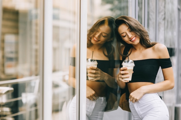 beautiful young girl drinking coffee in the city