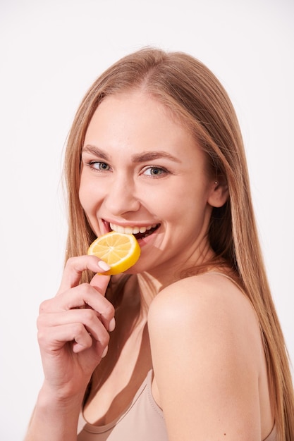 Beautiful young girl enjoying juicy fruits