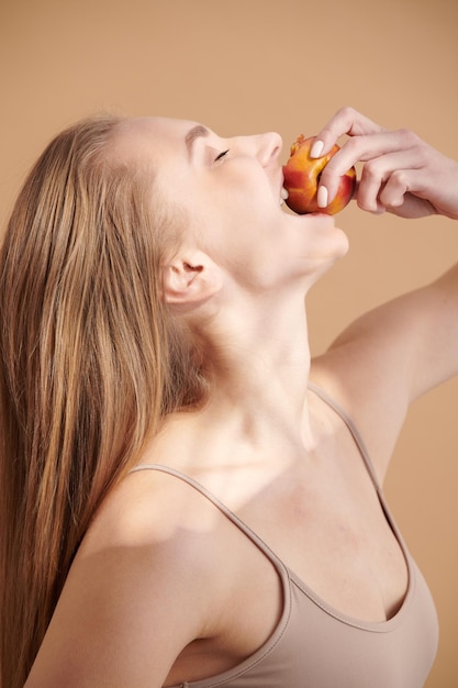 Beautiful young girl enjoying juicy fruits