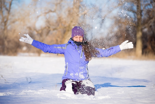 Beautiful young girl enjoys a walk in the park in winter.