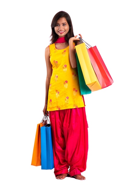 Beautiful young girl holding and posing with shopping bags on a white background