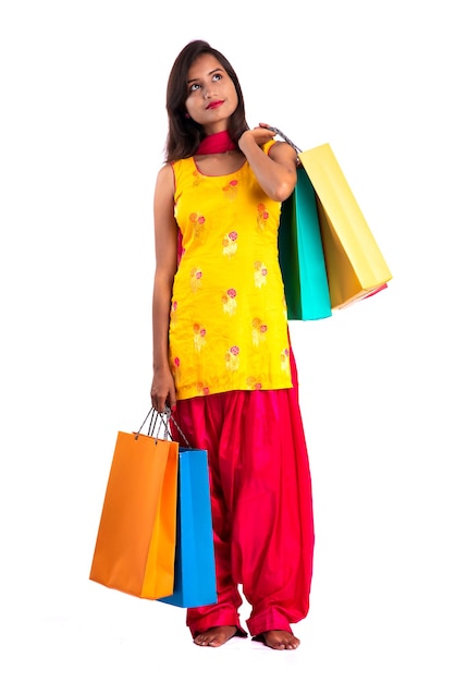 Beautiful young girl holding and posing with shopping bags on a white background