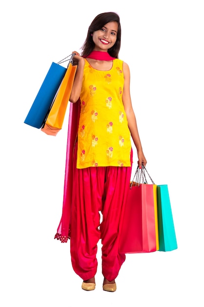 Beautiful young girl holding and posing with shopping bags on a white background