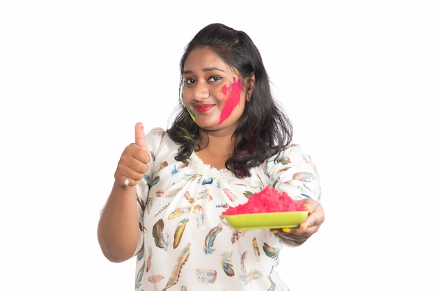 Beautiful young girl holding powdered color in plate on the occasion of Holi festival.