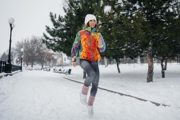 A beautiful young girl is Jogging on a frosty and snowy day. Sports, healthy lifestyle.