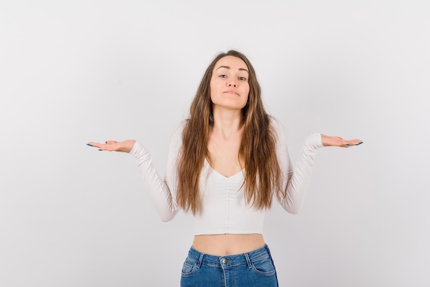 Beautiful young girl is opening wide her hands on white background