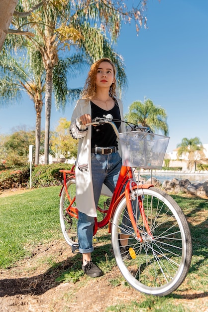 Beautiful young girl is riding the bicycle in the park