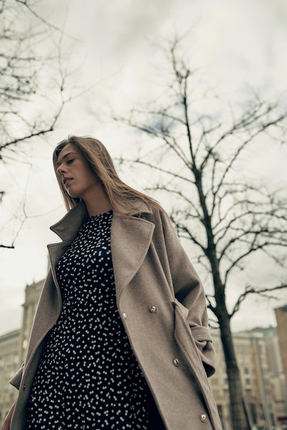 A beautiful young girl is walking in the city in autumn. Spring in the city. Beauty. thunderclouds.