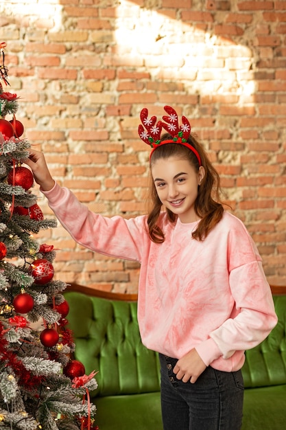 Beautiful young girl near the Christmas tree